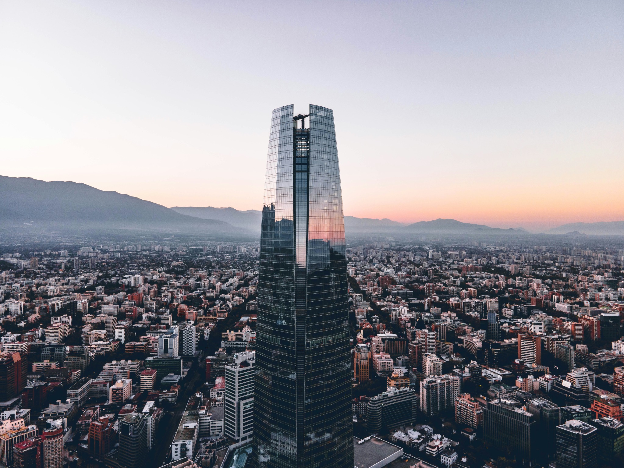 Skyline von Santiago de Chile mit einem hohen Glasturm und Bergen im Hintergrund